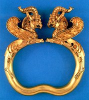 A pair of gold armlets with terminals in the shape of horned griffins